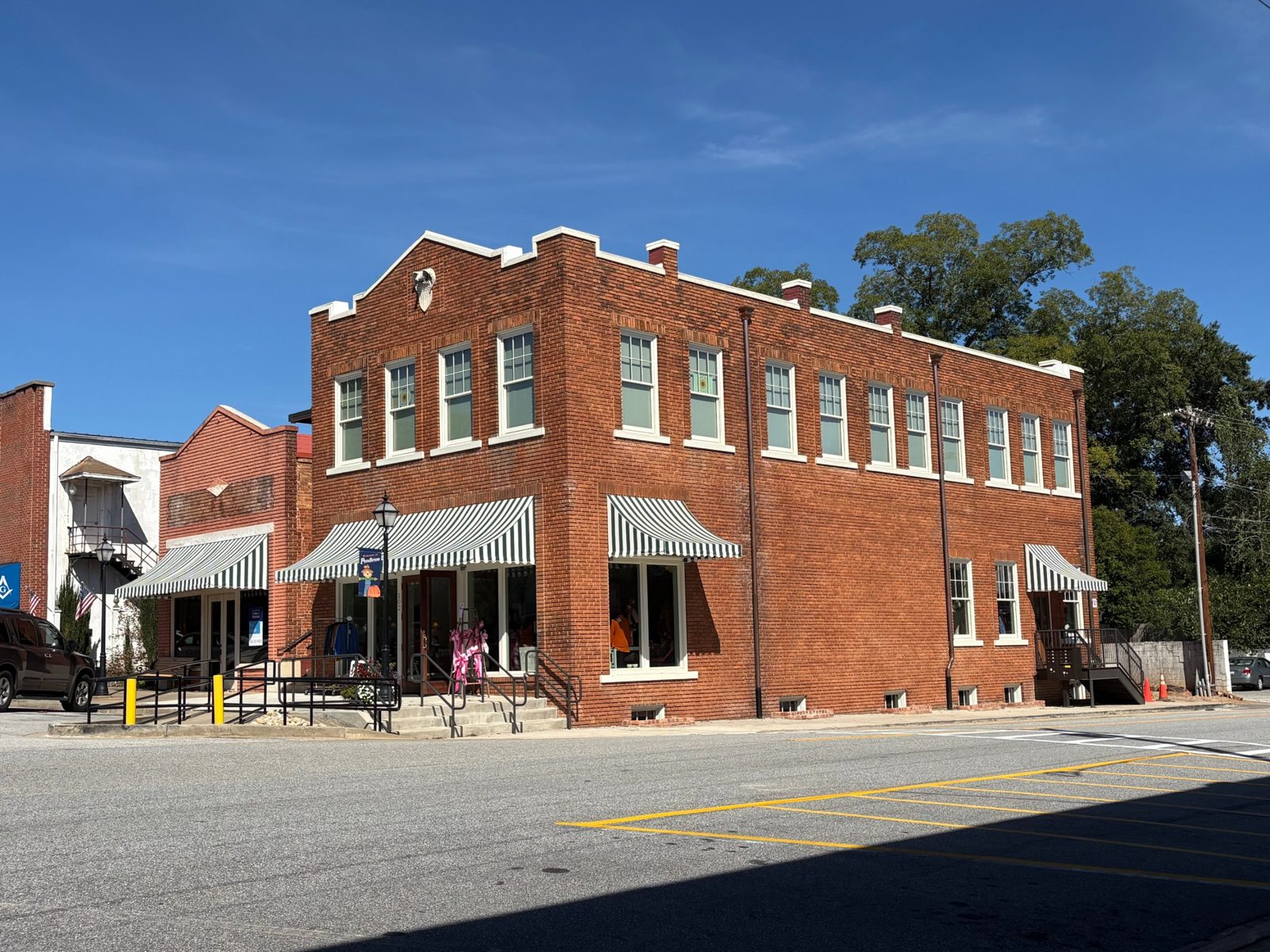The Newtique Boutique building on the Square in Pendleton, SC: red brick with green and white striped awnings